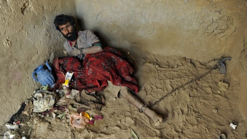 Piktųjų dvasių išvarymas: mėnuo vienutėje su grandinėmis ant kojų ir rankų  (foto, N-18)