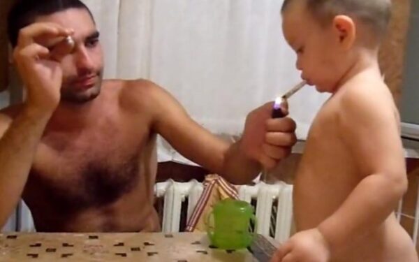 Dar nekalbantis berniukas tėčiui padedant mokosi rūkyti (video)