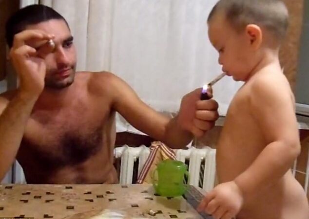 Dar nekalbantis berniukas tėčiui padedant mokosi rūkyti (video)