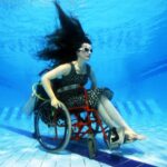 Neįgaliame vežimėlyje prikaustyta moteris atliko šokį po vandeniu (video)