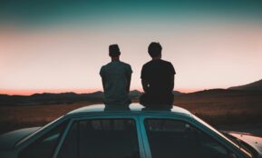 two men sitting on vehicle