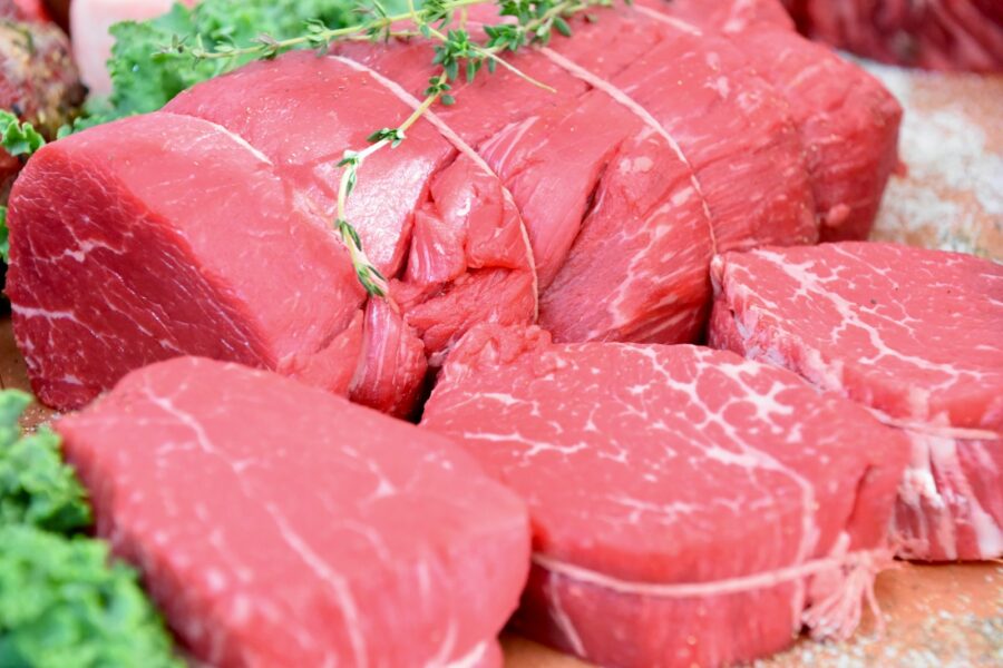 sliced raw meat on brown wooden table