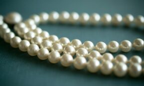 white pearl necklace on gray textile
