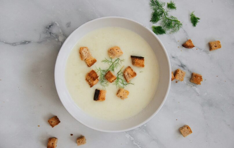 soup with green leaf on white ceramic bowl