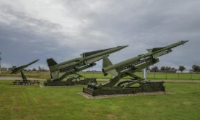 a group of military missiles sitting on top of a field