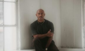 a man sitting on a window sill in front of a window