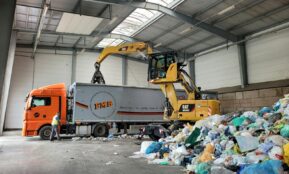 a large truck with a load of trash in a warehouse