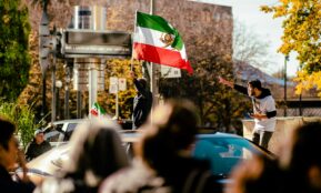 a group of people on a street with a person holding a flag