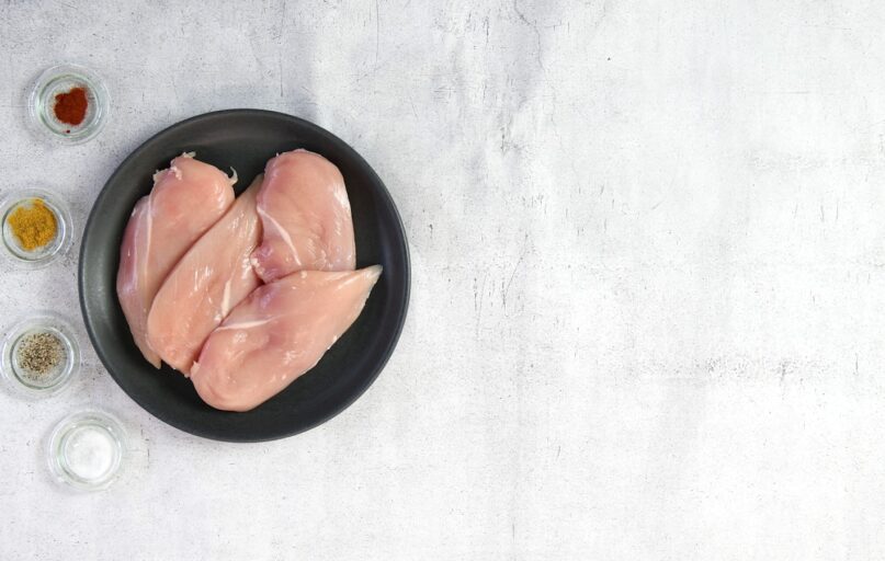 two raw chicken breasts in a black bowl
