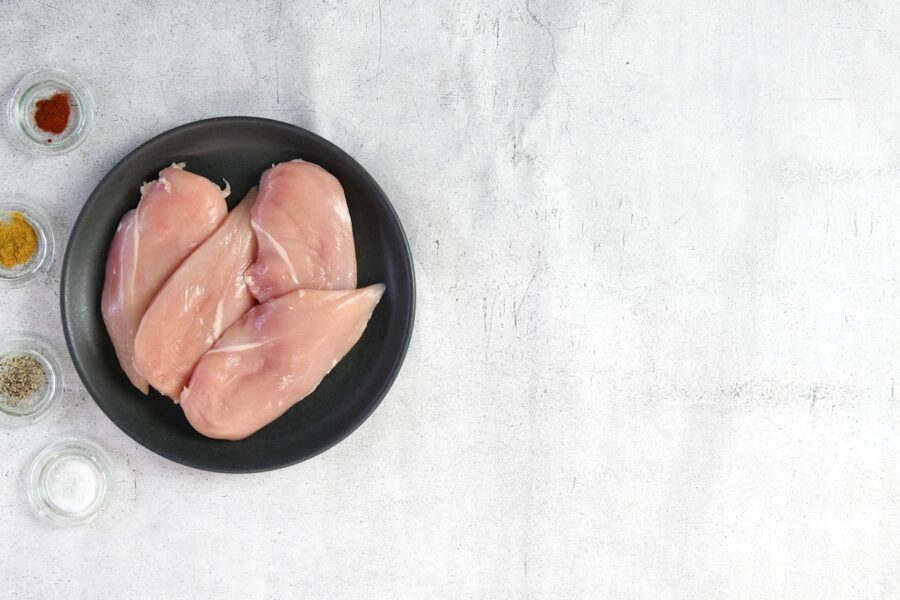two raw chicken breasts in a black bowl