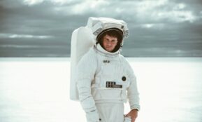 boy in white hoodie standing on snow covered ground during daytime