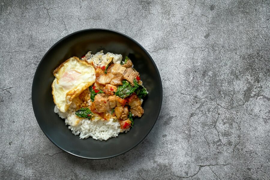 a black plate topped with rice and meat