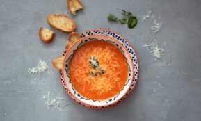 orange soup on white and blue ceramic bowl