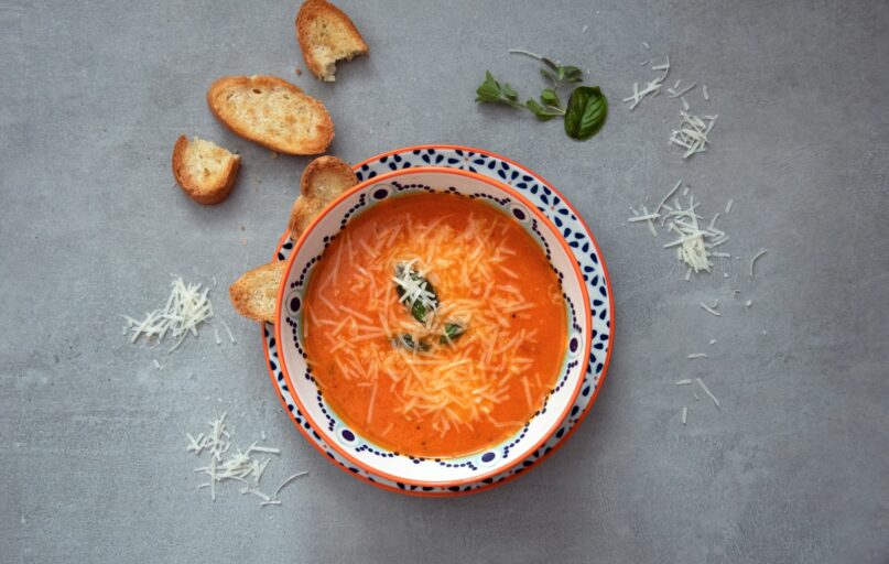orange soup on white and blue ceramic bowl