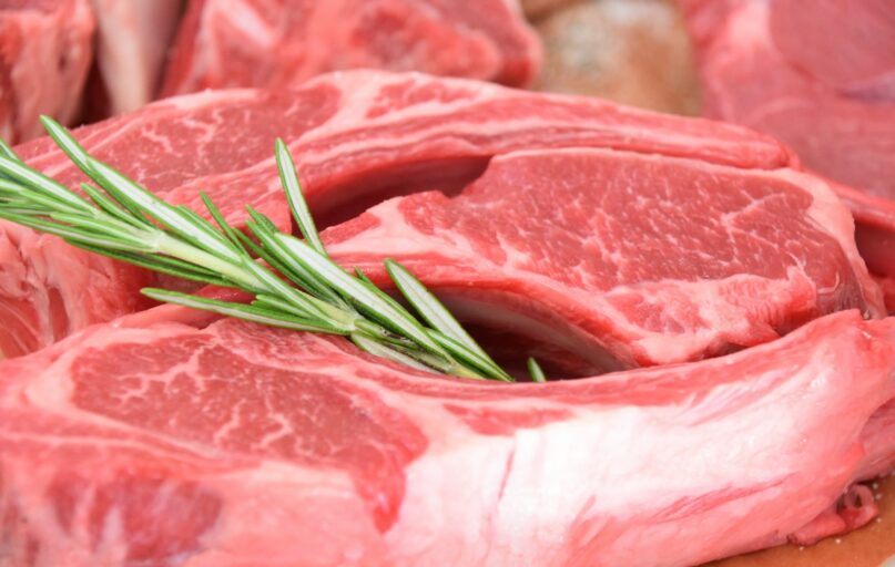 sliced raw meat with green leaves