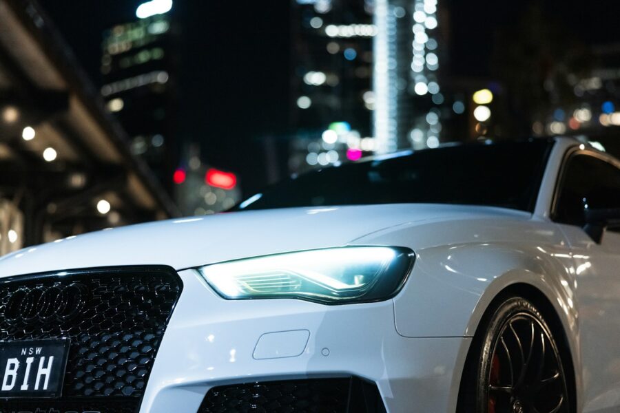 A white car is parked in the city at night.