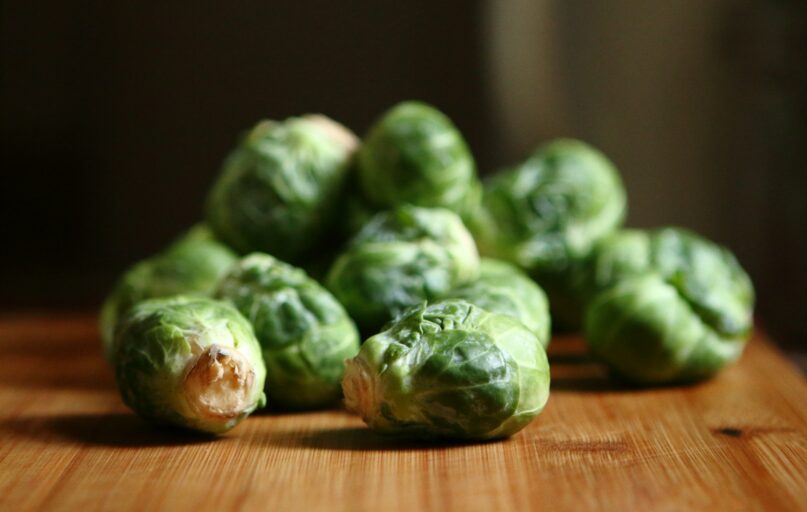 shallow depth of fields photography of green vegetable on brown wooden panel