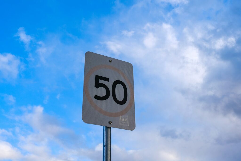 A speed limit sign in front of a cloudy sky