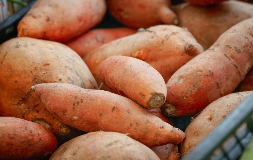 A pile of sweet potatoes in a basket.