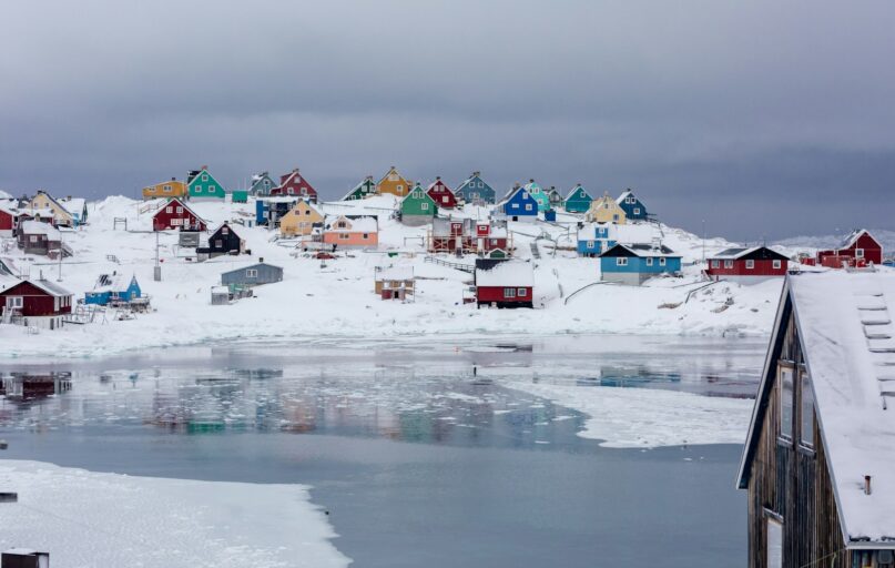 view photography of assorted-color houses near pond during daytime
