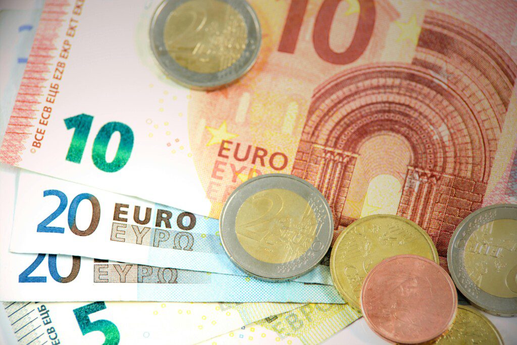 Detailed shot of Euro banknotes and coins showcasing currency denominations.