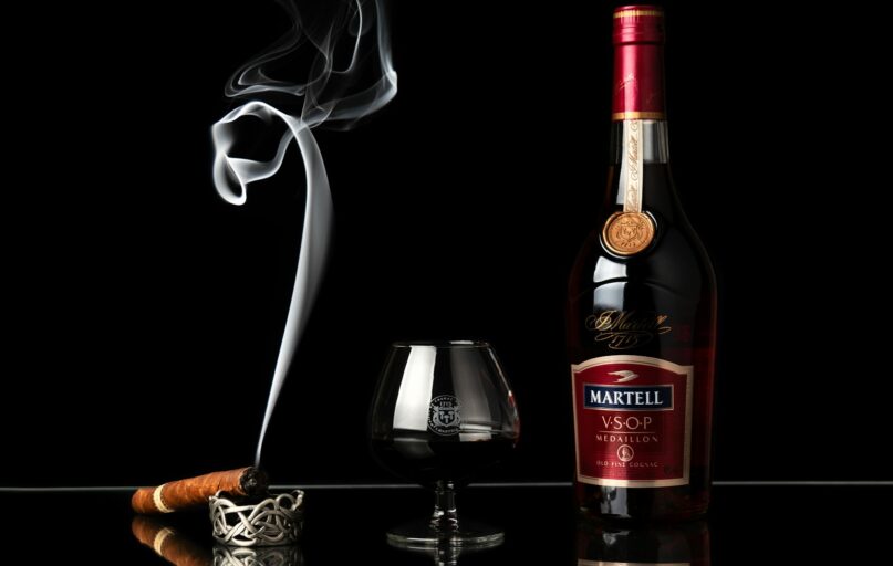 a bottle of wine next to a glass of wine