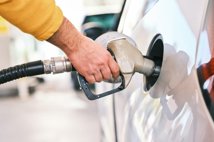 a man pumping gas into his car at a gas station