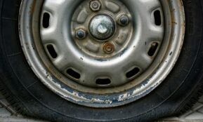 Close-up of a worn car tire and rim.
