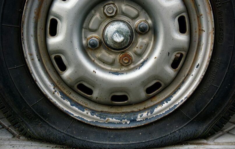 Close-up of a worn car tire and rim.