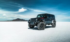 black jeep wrangler on snow covered field under blue sky during daytime