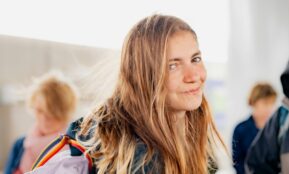 a woman with long hair and a backpack