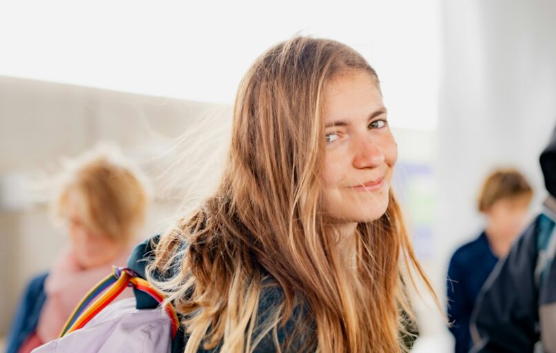 a woman with long hair and a backpack