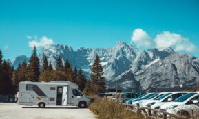 white and blue tent near green trees and mountain during daytime