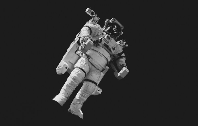 astronaut in white suit in grayscale photography