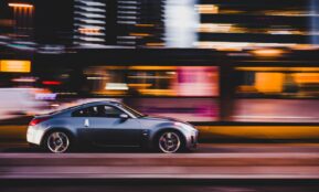 panning photography of gray coupe on road