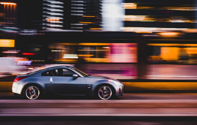 panning photography of gray coupe on road
