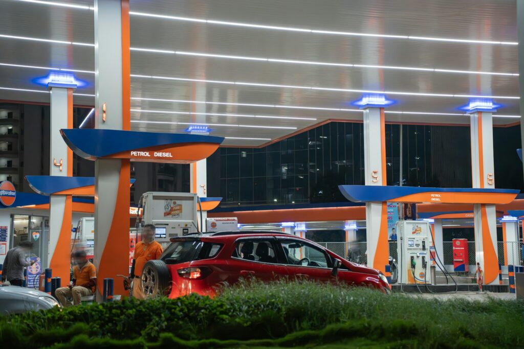 Red car at a brightly lit gas station at night