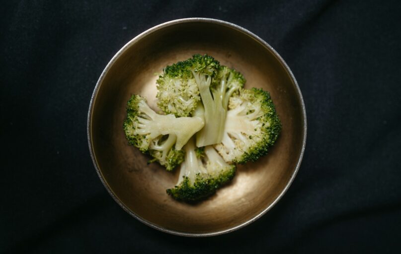 a metal bowl filled with broccoli florets