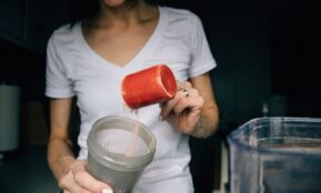 woman in white crew neck t-shirt holding red plastic cup
