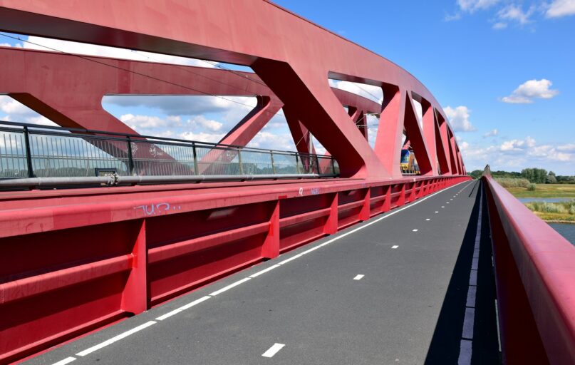 a red bridge over a body of water