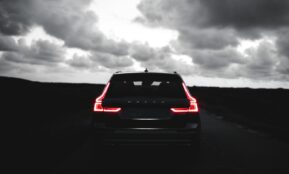 red car on black asphalt road under gray cloudy sky