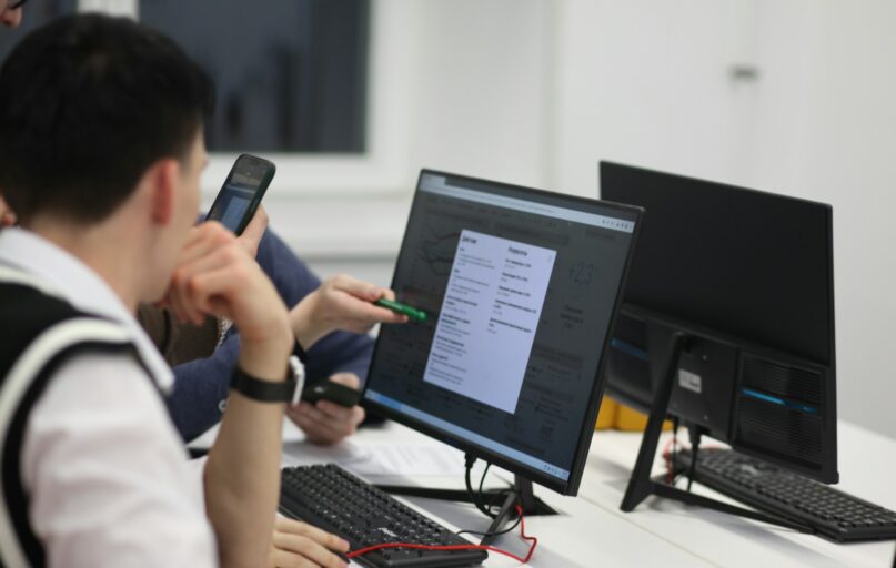 A group of people sitting at a table with computers