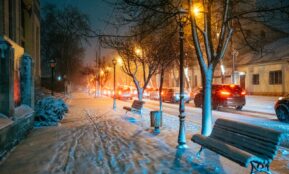 brown wooden bench on snow covered ground during night time