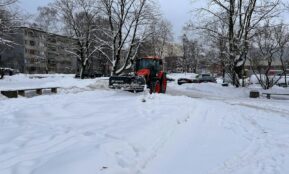 a snow plow is parked on a snowy street