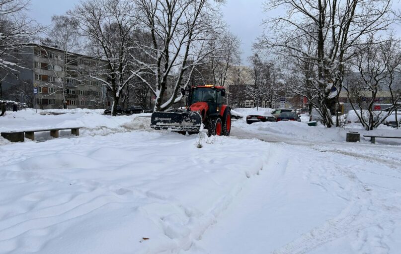 a snow plow is parked on a snowy street