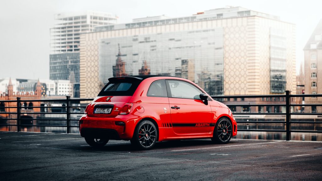 red and black bmw m 3 parked near white concrete building during daytime