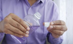 person holding white plastic bottle