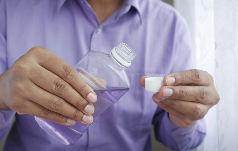 person holding white plastic bottle