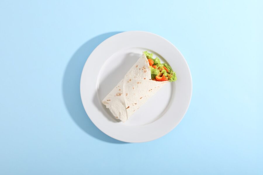 A wrap and salad on a white plate.