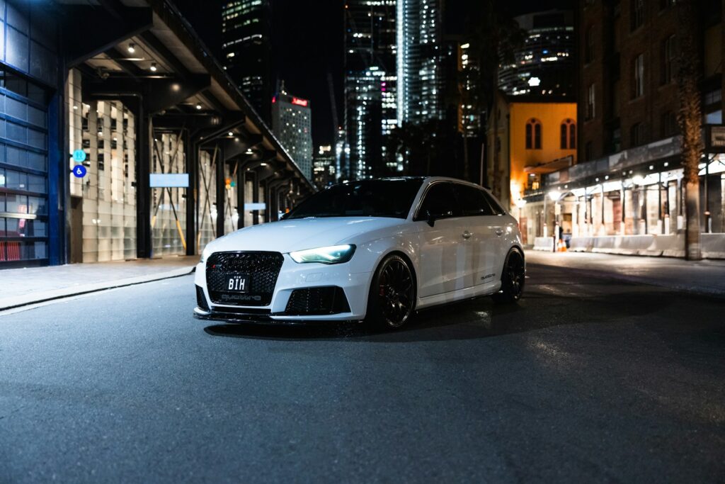 A white car is parked on a city street.